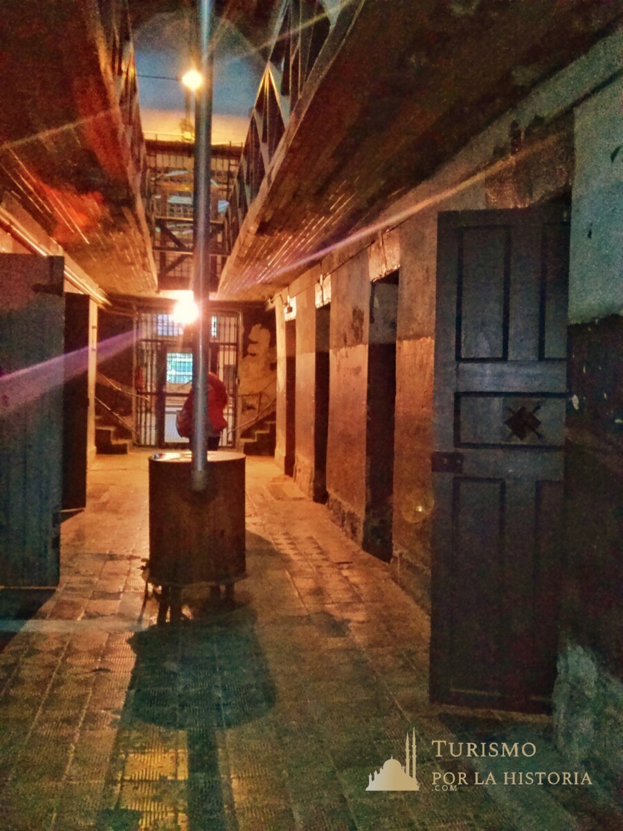 Interior del museo del presidio en la parte sin restaurar, donde se ve la caldera central y las puertas de adera alos costados en un largo pasillo. Ushuaia fin del mundo